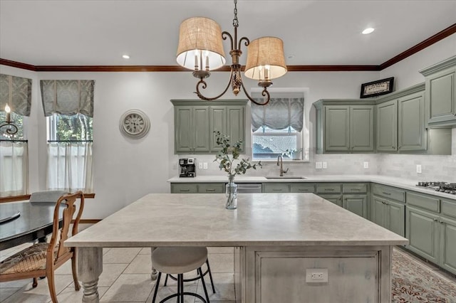 kitchen featuring light countertops, green cabinetry, a sink, and backsplash