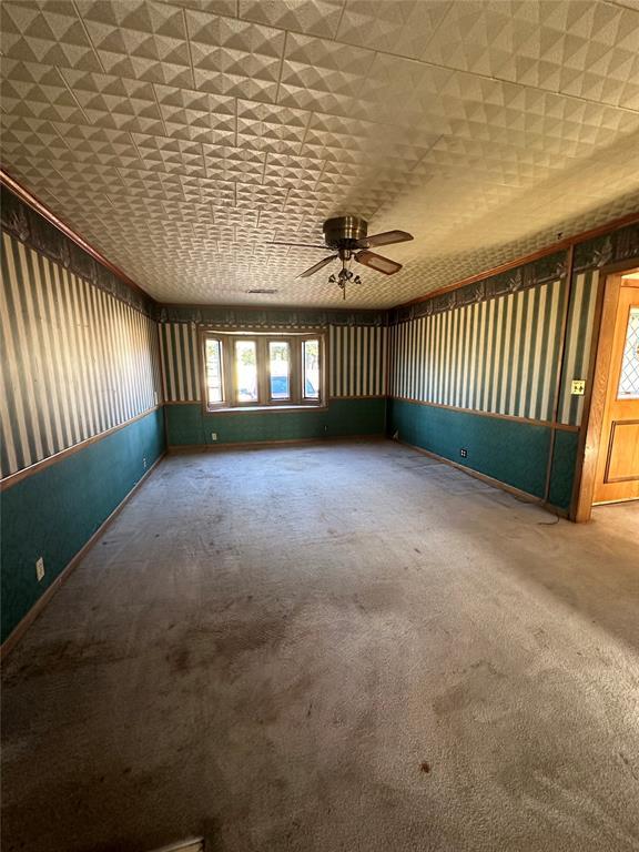 unfurnished room featuring carpet and ceiling fan