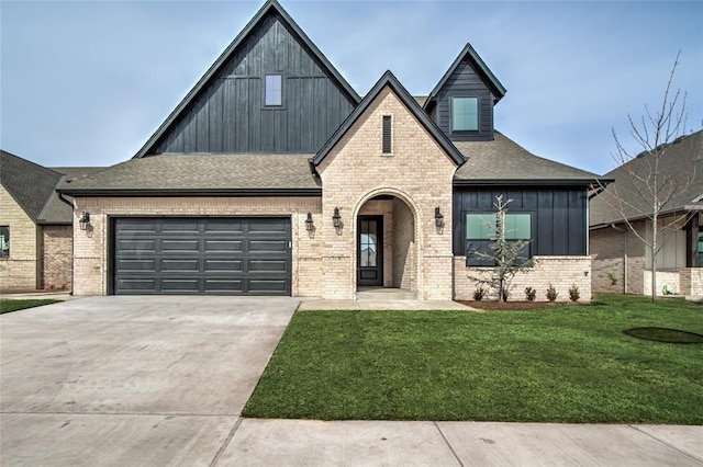 view of front facade with concrete driveway, brick siding, board and batten siding, and a front yard