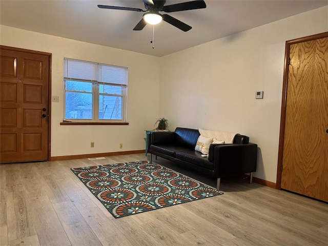 living room with ceiling fan and light hardwood / wood-style flooring