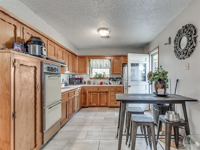 kitchen featuring double oven and a textured ceiling