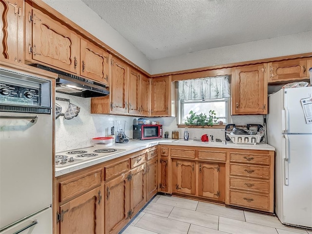 kitchen featuring sink, a textured ceiling, white appliances, and decorative backsplash