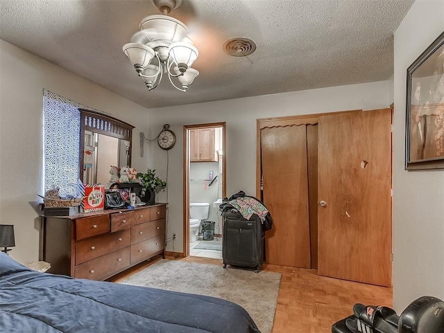 bedroom with light parquet flooring, connected bathroom, a chandelier, and a textured ceiling