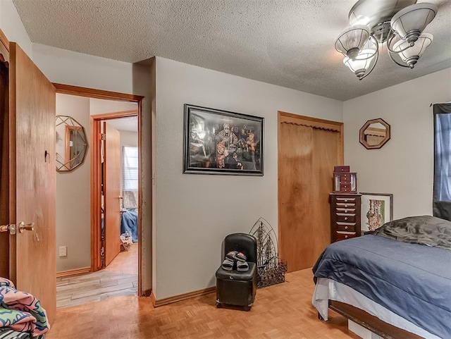 bedroom featuring light parquet flooring, a textured ceiling, and a closet