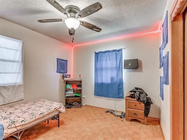 bedroom featuring ceiling fan, a textured ceiling, and light parquet floors