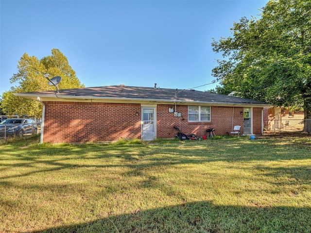 rear view of property with a yard