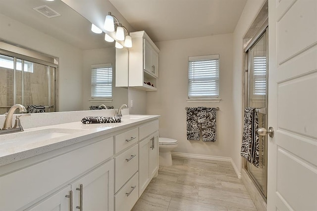 bathroom with vanity, toilet, and an enclosed shower