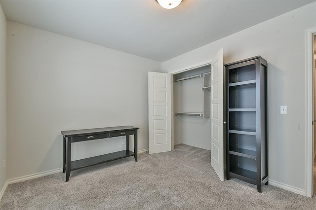 unfurnished bedroom featuring light colored carpet and a closet