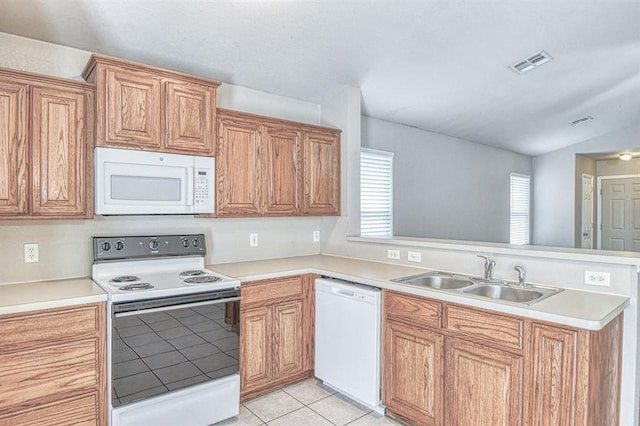 kitchen with white appliances, a sink, a peninsula, healthy amount of natural light, and lofted ceiling