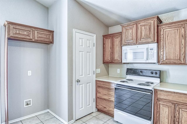 kitchen with white appliances, light tile patterned flooring, lofted ceiling, light countertops, and brown cabinetry