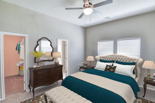 carpeted bedroom with a spacious closet, ceiling fan, a textured ceiling, a closet, and baseboards
