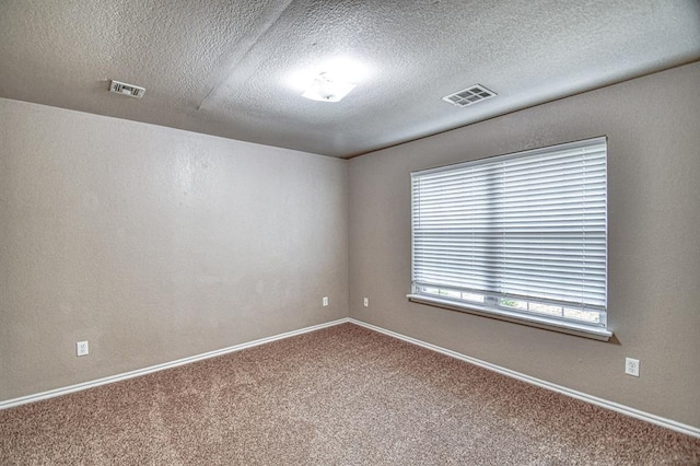 unfurnished room with carpet flooring, a textured ceiling, and baseboards