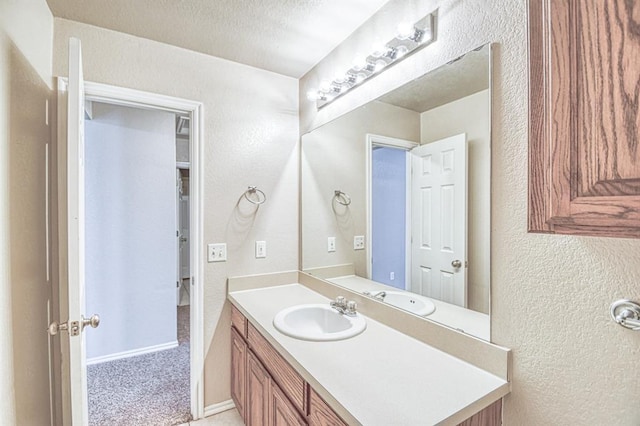 bathroom featuring a textured wall and vanity