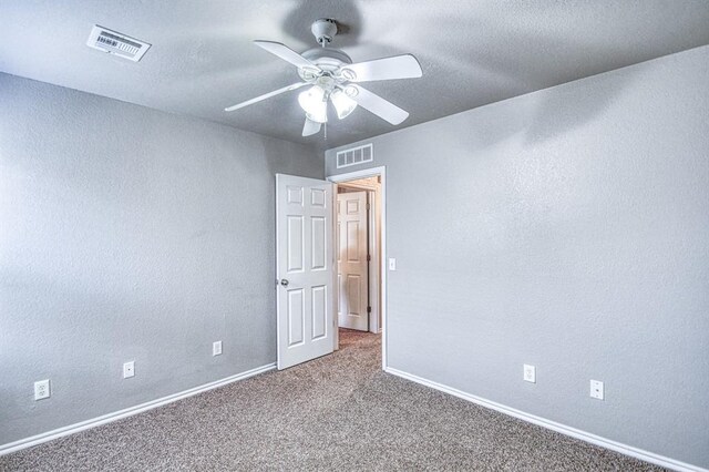 spare room with carpet, a ceiling fan, baseboards, and a textured wall