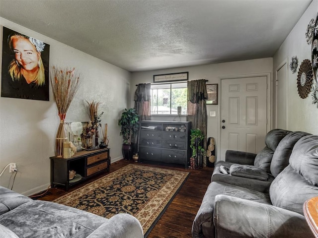 living room featuring dark hardwood / wood-style flooring and a textured ceiling