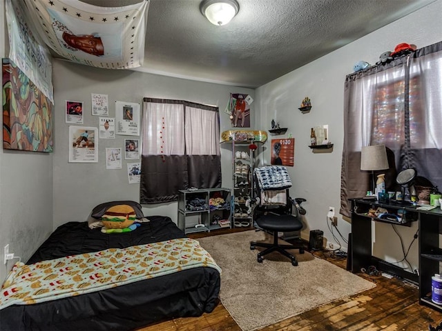 bedroom featuring hardwood / wood-style flooring and a textured ceiling