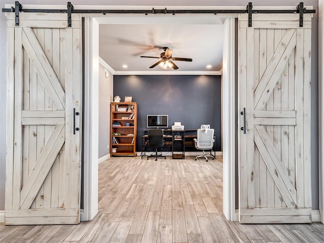 home office with crown molding, a barn door, and light hardwood / wood-style floors