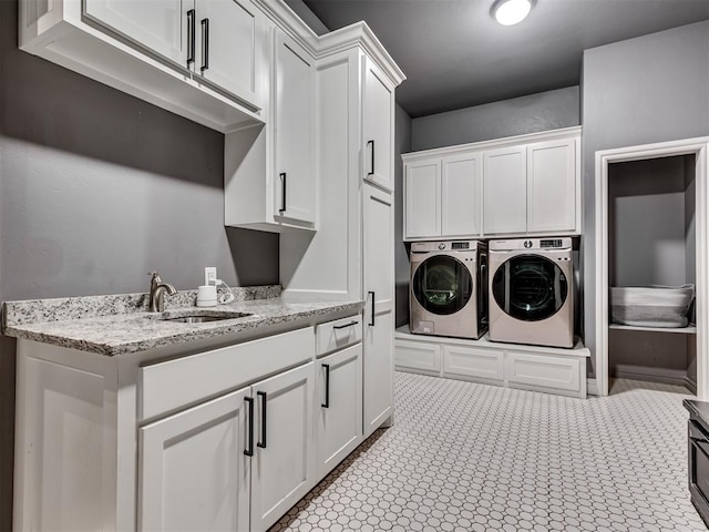 washroom featuring cabinets, sink, and washer and clothes dryer