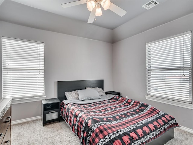 bedroom with multiple windows, light colored carpet, and ceiling fan