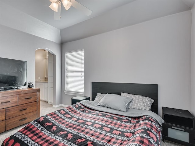 bedroom featuring lofted ceiling, light colored carpet, connected bathroom, and ceiling fan