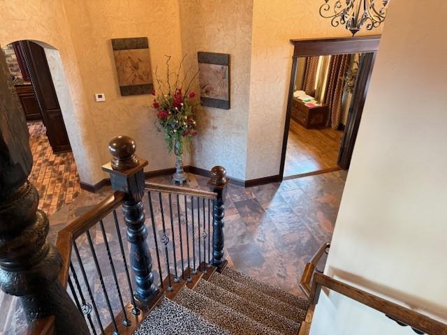 stairway featuring a chandelier