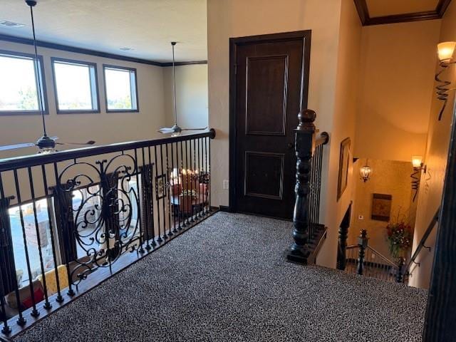 interior space featuring crown molding, carpet flooring, and ceiling fan