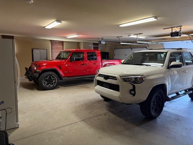 garage with a garage door opener and white fridge