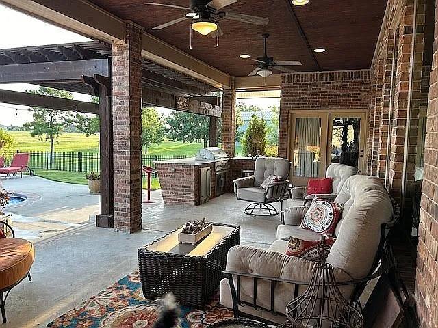 view of patio / terrace featuring exterior kitchen, area for grilling, an outdoor hangout area, and ceiling fan