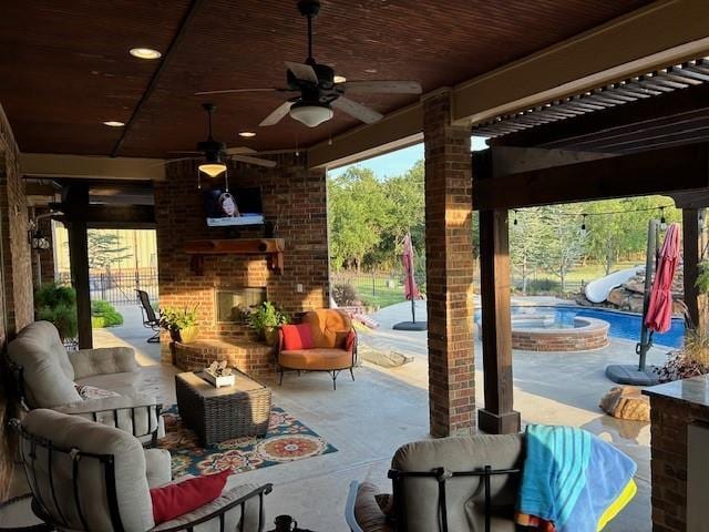 view of patio with an outdoor living space with a fireplace and ceiling fan