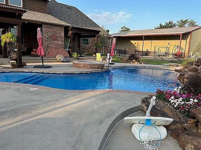 view of swimming pool with a patio area and an in ground hot tub