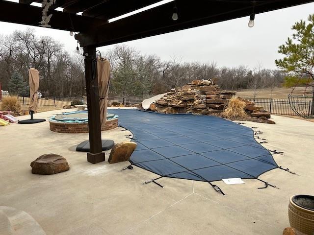 view of pool featuring a hot tub, a water slide, and a patio area