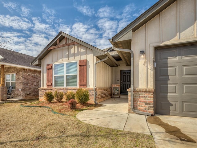 property entrance featuring a garage, board and batten siding, and brick siding