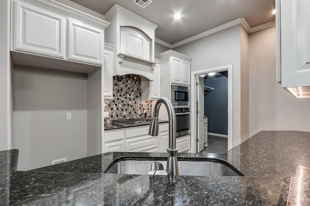 kitchen featuring stainless steel appliances, a sink, white cabinetry, ornamental molding, and decorative backsplash