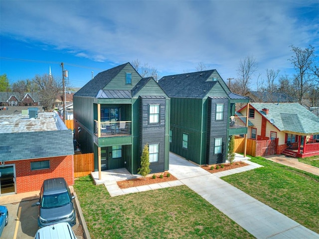 view of front of house featuring a balcony and a front yard