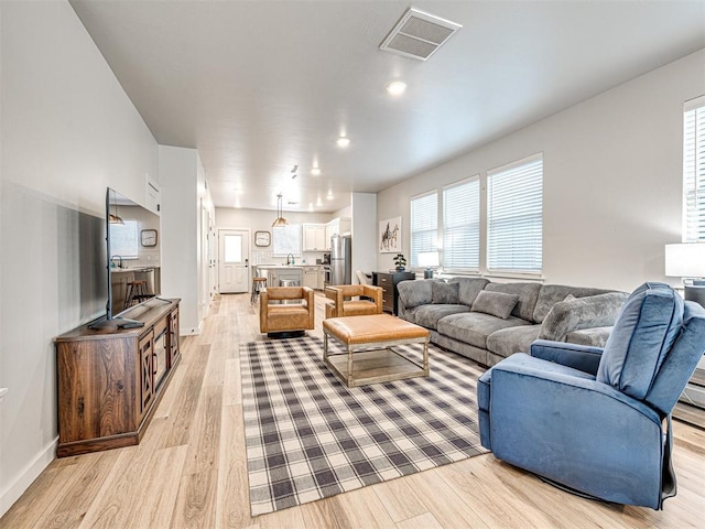 living room featuring plenty of natural light and light hardwood / wood-style flooring