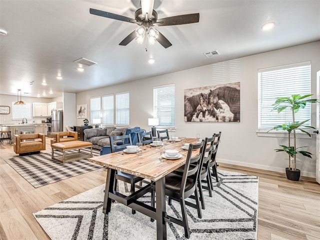 dining area with ceiling fan and light wood-type flooring