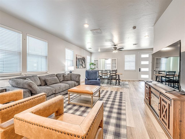 living room featuring light hardwood / wood-style flooring and ceiling fan