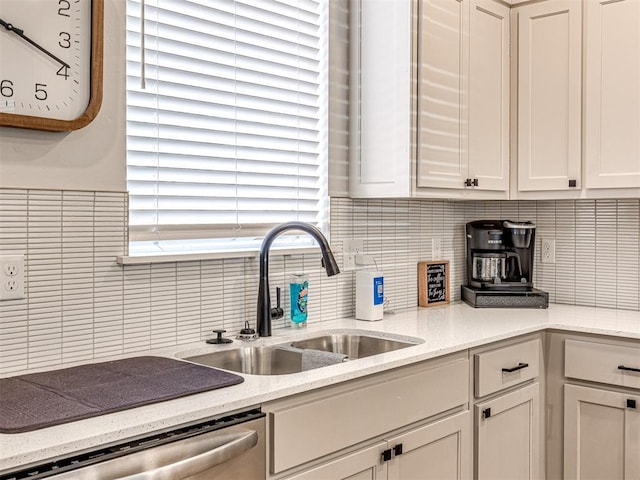 kitchen featuring backsplash, dishwasher, sink, and white cabinets