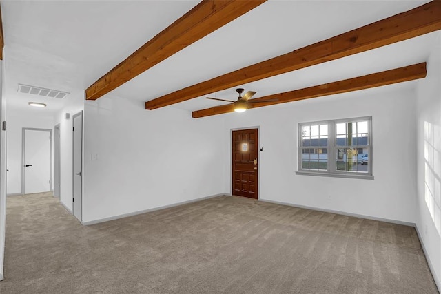 carpeted empty room with beam ceiling