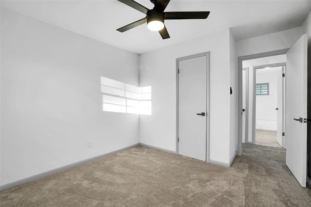 unfurnished bedroom with ceiling fan, light colored carpet, and multiple windows