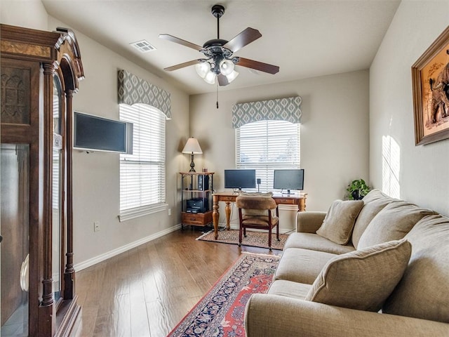 office with baseboards, ceiling fan, visible vents, and wood finished floors