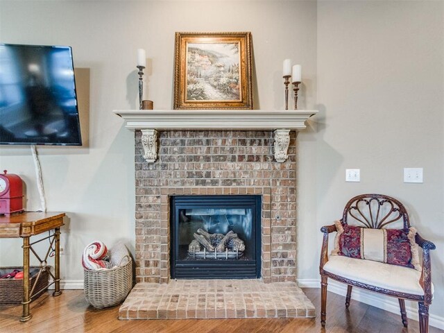 interior details featuring baseboards, a fireplace, and wood finished floors