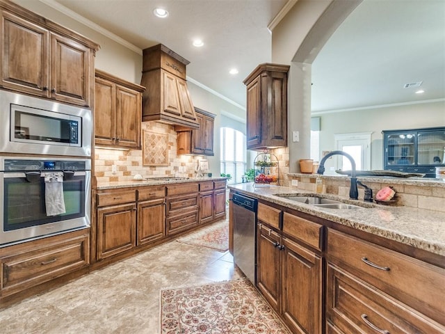 kitchen with crown molding, light stone counters, a sink, stainless steel appliances, and arched walkways