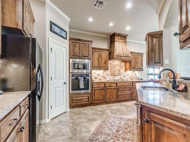 kitchen featuring tasteful backsplash, a sink, visible vents, light stone countertops, and appliances with stainless steel finishes