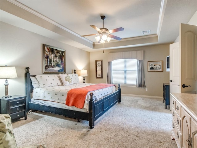 bedroom featuring crown molding, a raised ceiling, light carpet, baseboards, and visible vents