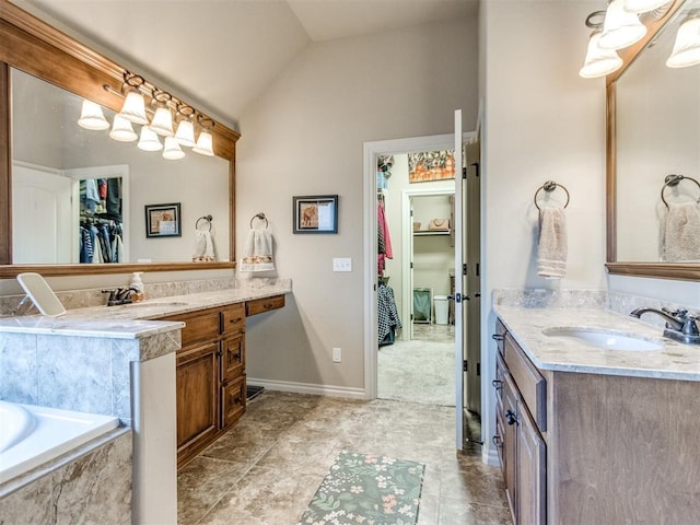 bathroom featuring a tub with marble appearance, a sink, vaulted ceiling, and two vanities