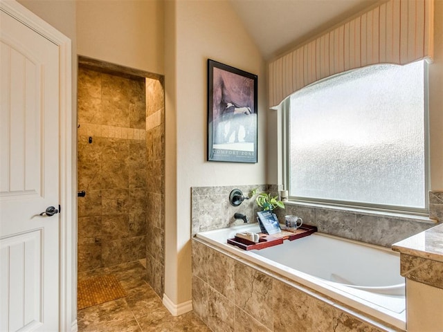 full bath with a bath, vaulted ceiling, tile patterned floors, and tiled shower