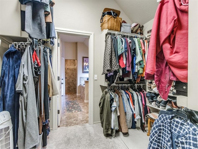 spacious closet with lofted ceiling and carpet floors
