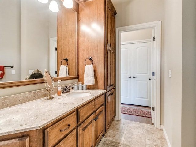 bathroom with tile patterned flooring, vanity, and baseboards