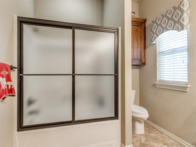 bathroom with tile patterned flooring, toilet, enclosed tub / shower combo, and baseboards